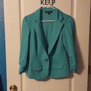Light teal jacket one button and mock pockets. Very light & dress up or down.